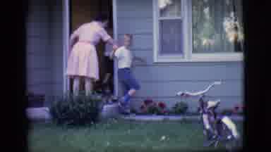 Des Moines Iowa (1966): Kid Waving Goodbye To Camera As His Mom Pulls Him Into The