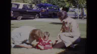 Evansville Indiana USA (1967): Two Older Women Kneeling Playing With A Small Baby
