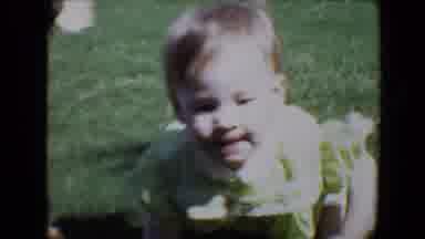 Evansville Indiana USA (1967): A Baby Girl In Yellow Dress Crawling On The Grass