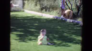 EVANSVILLE INDIANA USA-1967: A Toddler Sits On Green Grass As A Woman Photographs Her