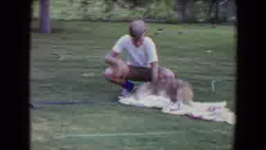 Flagstaff Arizona (1961): Man Wearing Tan Pants Rub Tan Dog With White Towel