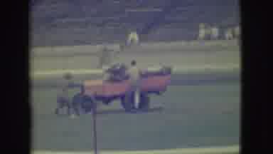 Denver Colorado (1949): Three People Get In A Red Convertible Car In A Stadium As
