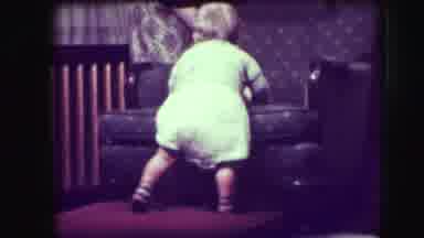 Union City New Jersey (1942): Baby Wearing White Jumper Tries To Climb Onto Brown