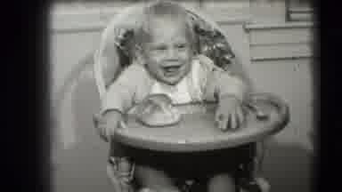 Levittown New York (1942): A Baby Laughing While Sitting In A High Chair In A