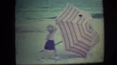 Long Beach New York (1946): Kid Playing With Big Umbrella On Beach
