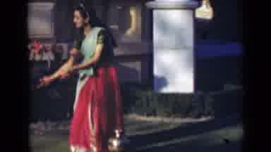 India (1947): Girl In Long Pink Skirt Wearing A Sari Is Dancing Near What Appears