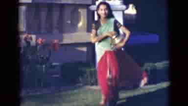 India (1947): Woman Wearing Green And Red Sari Places Gold Jug On Green Grass On A