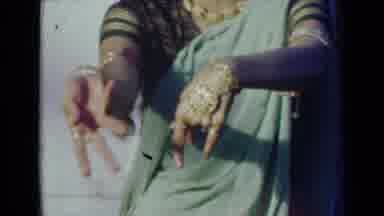 India (1947): A Woman Dancing With Her Arms While Wearing Golden Indian Jewelry