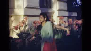 India (1947): A Beautiful Indian Woman Dancing Outside Near Flowers