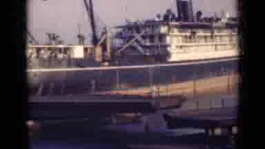 India (1947): People Are Running Toward Ship That Is Stranded On A Port