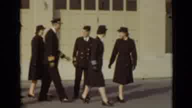 New York (1947): Group Of People Wearing Black Suits Walk Past White Garage On A