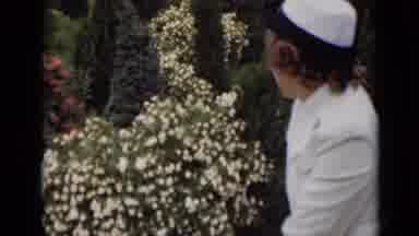 New York (1947): Woman Sitting In A Garden Wearing White Turns Her Head To Look As