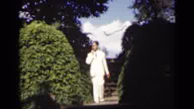 New York (1947): Man Walks Down Street In White Suite While Smoking And Smiling