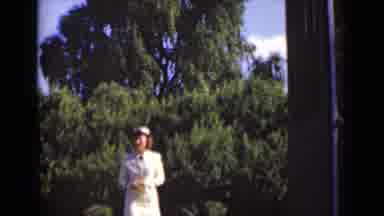 New York (1947): Woman Wearing White Suit Approaches Open Doorway On A Sunny Day