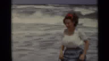 New York (1947): Woman Wearing Blue Skirt Runs From Ocean Waves On A Sunny Day