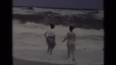 New York (1947): Two Women Standing On A Beach As Huge Waves Come In On A Very