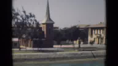 Suez Canal Egypt (1946): Driving Down Street Past Two Brick Buildings In A Small