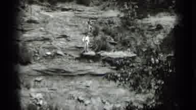 Clear Lake California (1939): Person Waving While Standing On Rocks In On A Cliff