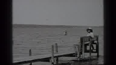 Clear Lake California (1939): Women Sitting On A Bench While People Canoe Behind