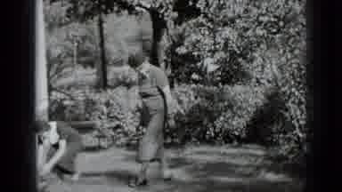 New York USA (1939): One Woman Bending Down In Yard Picking Up Foliage To Show