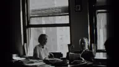 New York USA (1939): A Man And Woman Sit Behind A Desk Looking At Paperwork