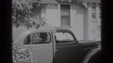 New York USA (1939): Couple Arriving Man Driving Antique Car Woman Opens Door