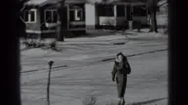 New York USA (1939): A Woman Bundled Up Against The Cold Walks Down The Sidewalk