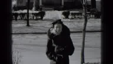 New York USA (1939): A Woman Dressed In A Coat Walks In The Rain While A Man