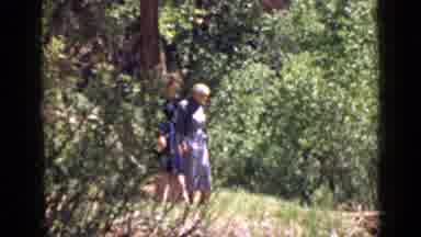 Utah USA (1939): Two Women In Dresses Walking Downhill On Green Grass With Trees