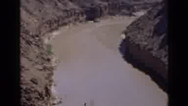 Utah USA (1939): A Slow Moving And Muddy River Flows Between Two Hills Of Mud And