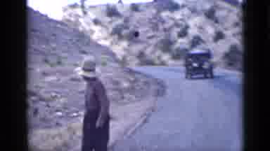 Utah USA (1939): Man Walking Quickly On Side Of Road In Mountain Setting While Car