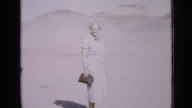 Utah USA (1939): Older Woman In A Plain Blue Dress Holding A Clutch Bag Stands In