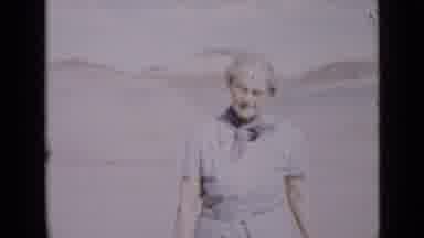 Utah USA (1939): Two Women Walk In The Desert In Front Of Sand Dunes In A Strong