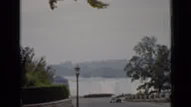 ONTARIO CANADA-1940: Man Walks By In A Park Surrounded With Buildings And A Waterfall