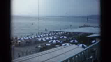 Cannes France (1962): A View Overlooking A Beach With Lots Of Chairs And Blue And
