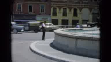 Cannes France (1962): A Man Standing In Front Of A Fountain Cars Driving Around