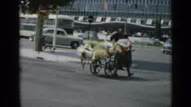Cannes France (1962): A Busy City Area With Vehicles A Woman Carrying A Cart
