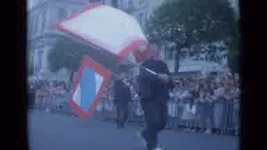 Cannes France (1962): Parade With People Waving A Flag With A Red Square Blue And