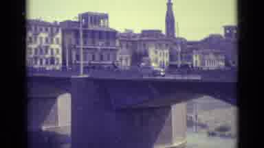 Florence Italy-1962: Cars Traveling On A Concrete Bridge Over A Water Way