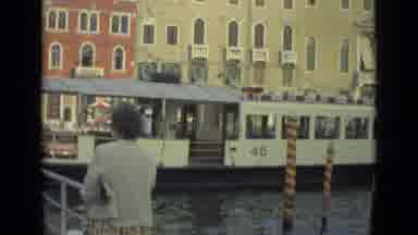Florence Italy (1962): A Ferry Going By People Next To It With Buildings Next To