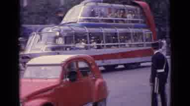 Germany (1962): View Of Street From Moving Vehicle Showing Cars And Large Bus Full