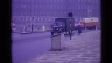 London England (1962): Traffic Going Down The Street And Army Boys Walking Out Of