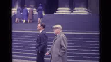 London England (1962): Two Men Walking Past A Set Of Stairs Leading To A Large