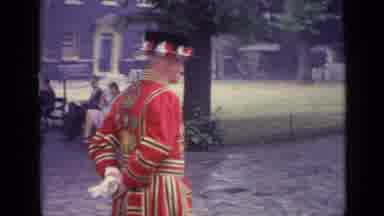 London England (1962): A Man In A Red Suit Waving To Someone Passing By In A