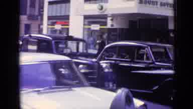London England (1962): View Of A Downtown Area With Very Tall Structures And
