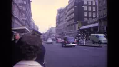 London England (1962): People Wait To Cross The Street At The Busses And Cars Go