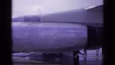 London England (1962): Airplane Parked While A Lady Is Walking By The Camera As
