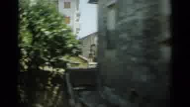 Monaco City (1962): Driving By Buildings And Trees In An Old Town