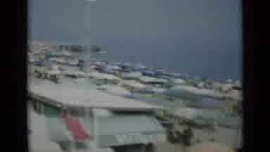 Monaco City (1962): Passing View Of Open Umbrellas Lined Up Along Beach On A