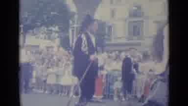Nice France (1962): A Man In Black With A Strange Hat Walks Past A Large Crowd
